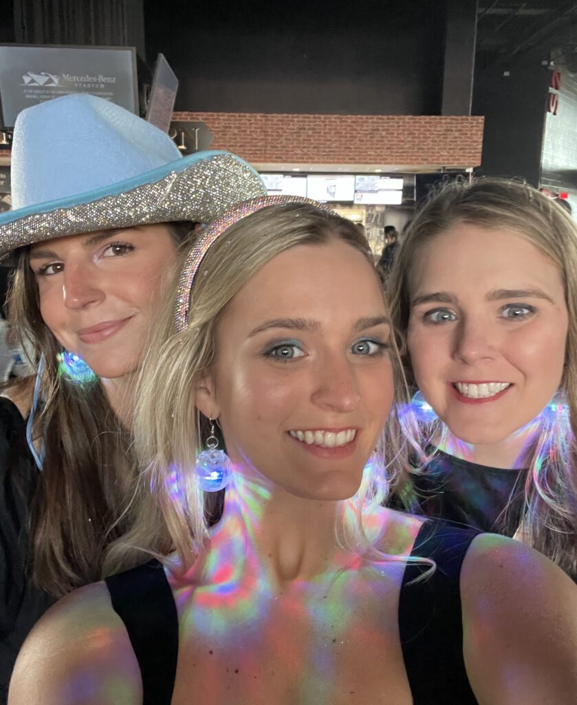 Selfie of three women, including author Anna Lipscomb (center), at Taylor Swift Eras Tour show.